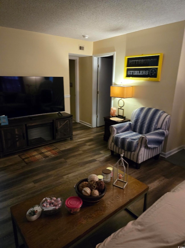 Living area with a textured ceiling, wood finished