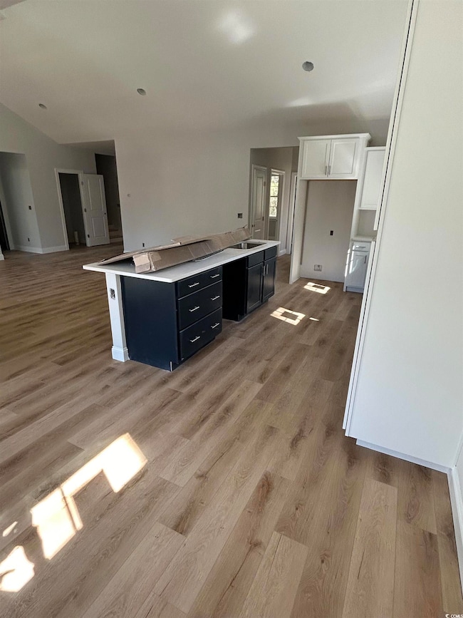 Kitchen featuring white cabinetry, open floor plan