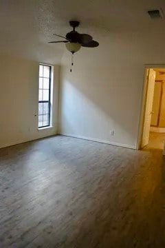 Spare room featuring a textured ceiling, a ceiling fan, and wood finished floors