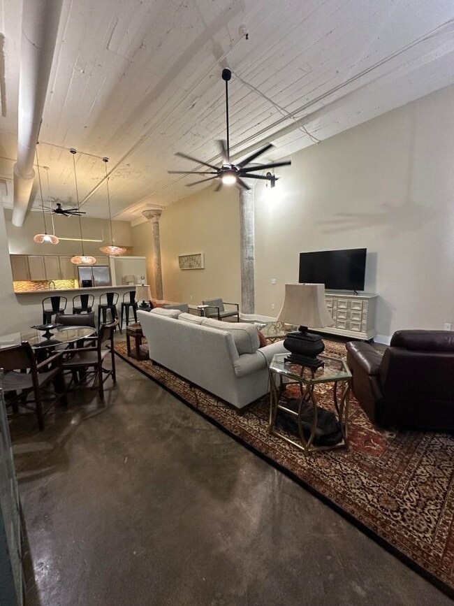 Living room featuring ceiling fan and decorative columns