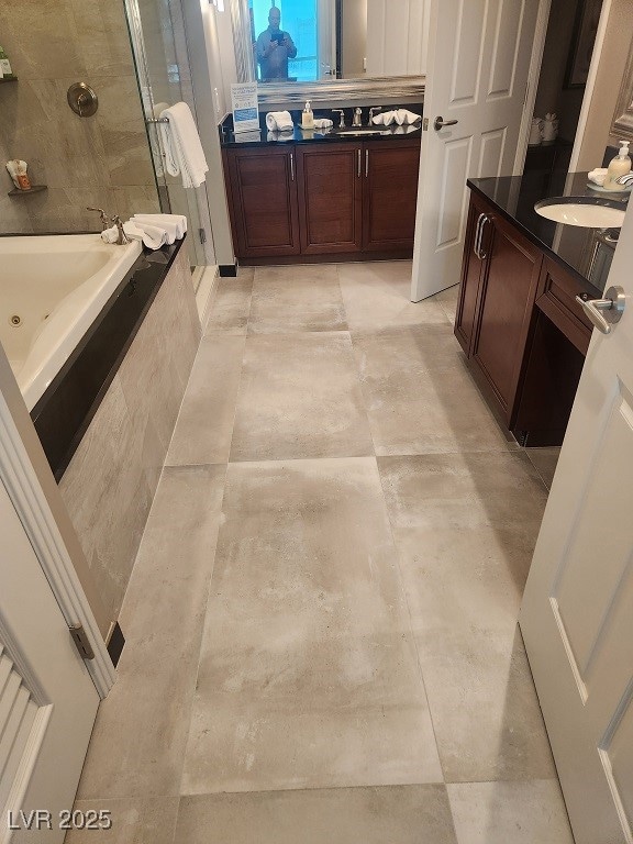 Bathroom with a shower stall, vanity, and a jetted