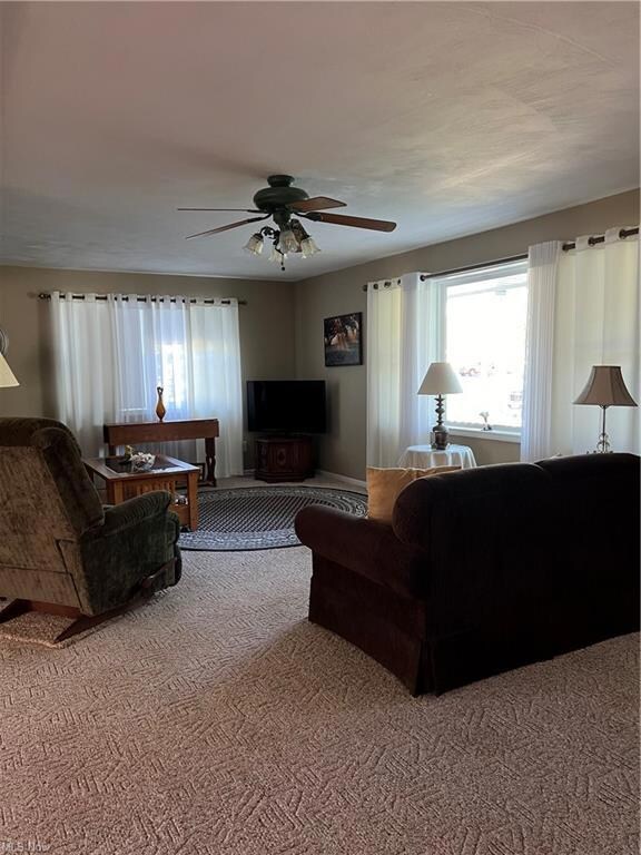 Living room with carpet floors and ceiling fan