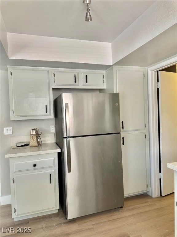 Kitchen with freestanding refrigerator, light coun