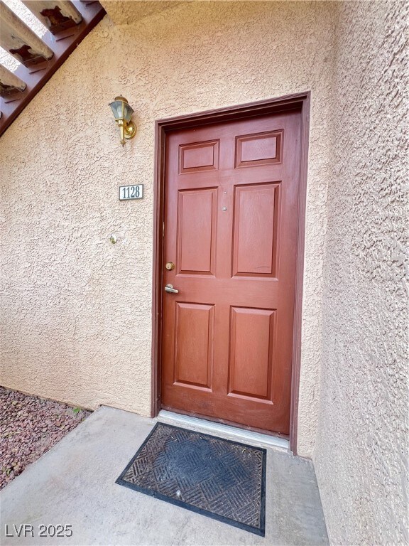 Property entrance featuring stucco siding