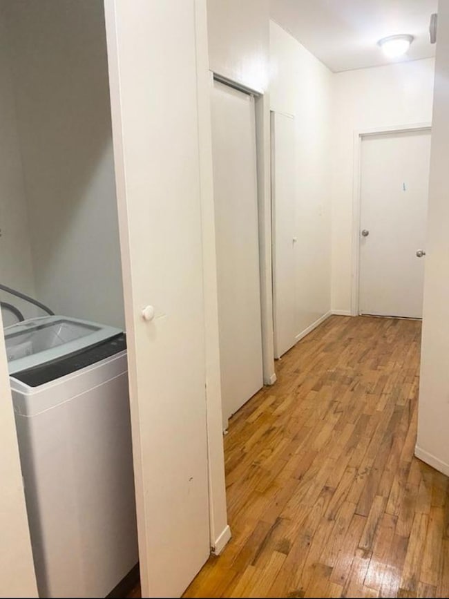 Laundry area with light wood-style flooring and washer / dryer