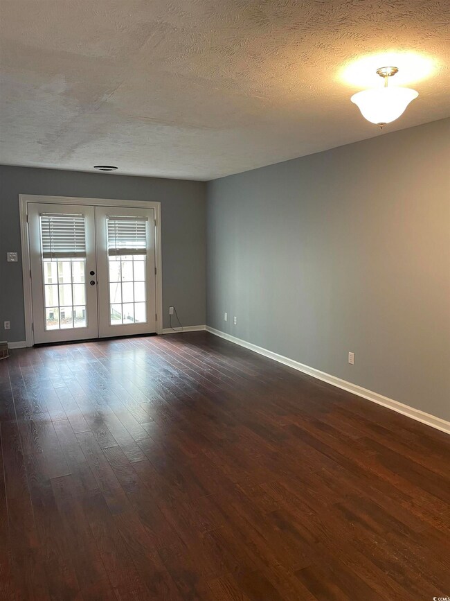 Unfurnished room with dark hardwood / wood-style f