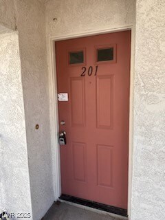 Property entrance featuring stucco siding