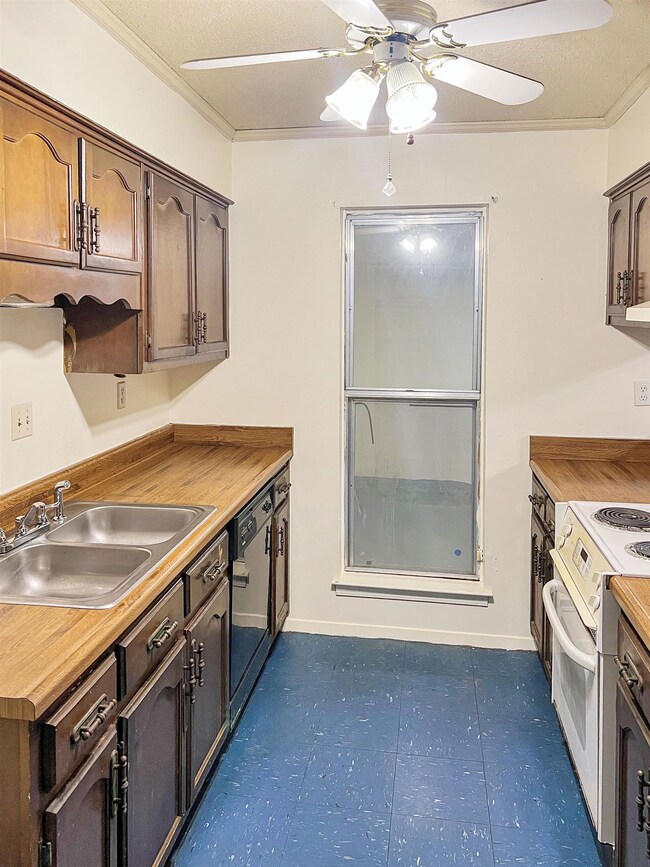 Kitchen featuring butcher block countertops, crown