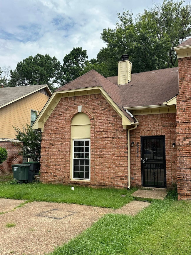 View of front of home with a chimney, brick siding, and a shingled roof