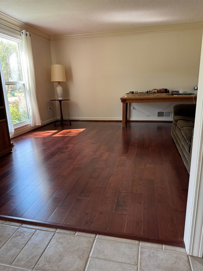 Spare room with wood-type flooring, ornamental molding, and a textured ceiling