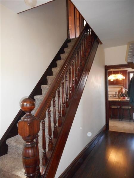 Original wood banister and light fixture in entry
