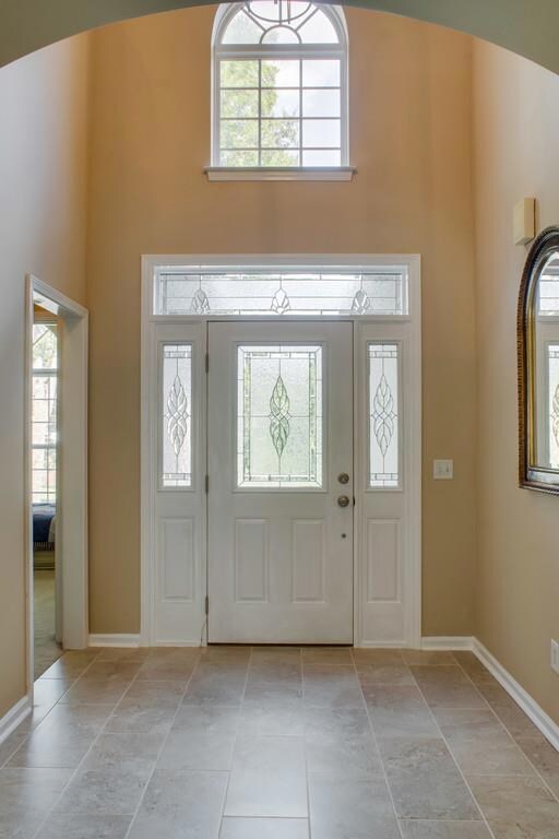 Warm and inviting two story foyer with new tile floor entry.