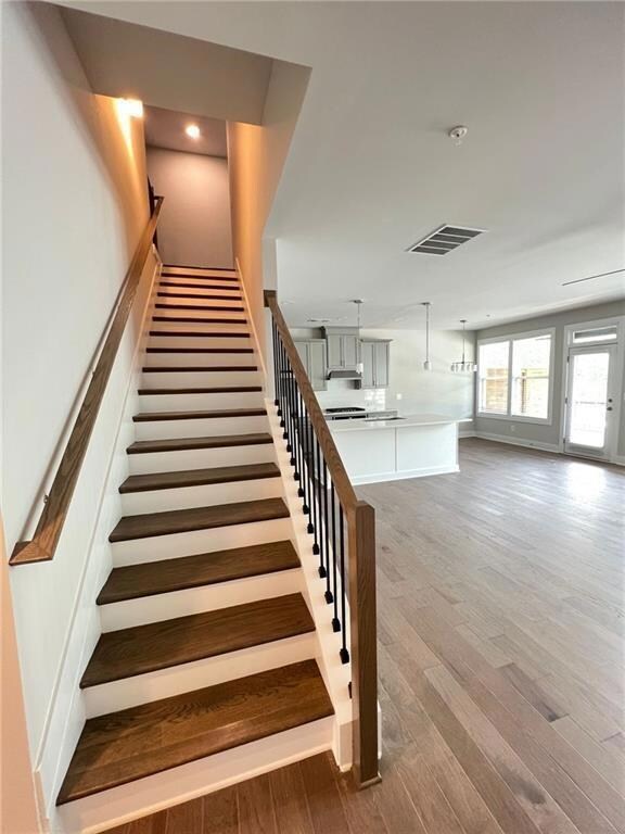 Stairs featuring visible vents and wood finished f