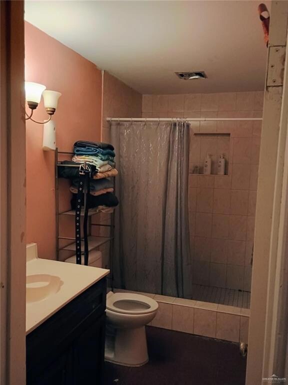 Bathroom featuring a shower stall, vanity, and dark tile patterned floors