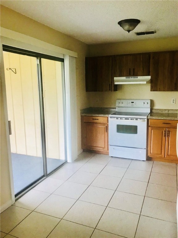 SLIDING GLASS DOORS LEAD TO COVERED SCREENED PATIO