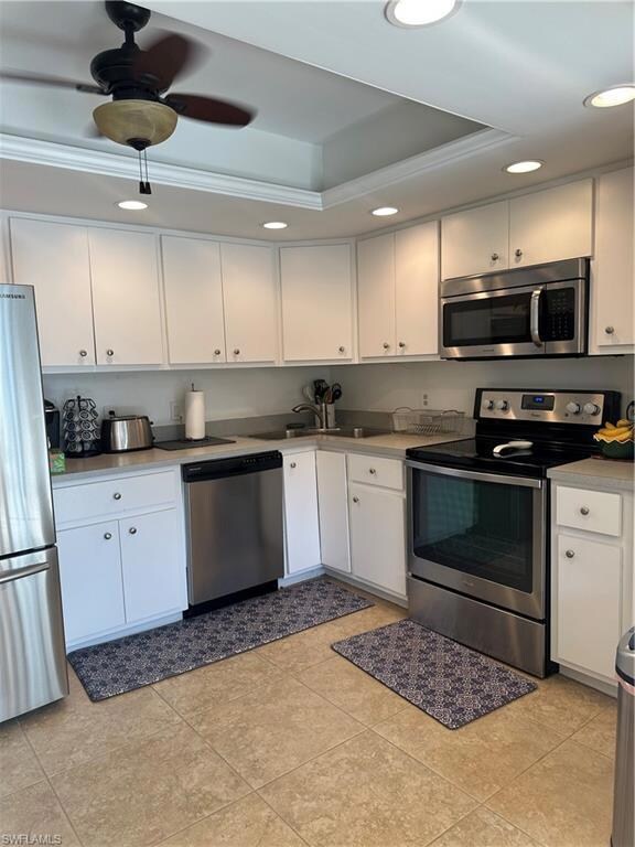 Kitchen featuring white cabinetry, fridge, a tray 