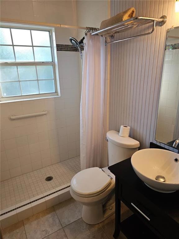 Bathroom with a stall shower, vanity, a baseboard radiator, and tile patterned flooring