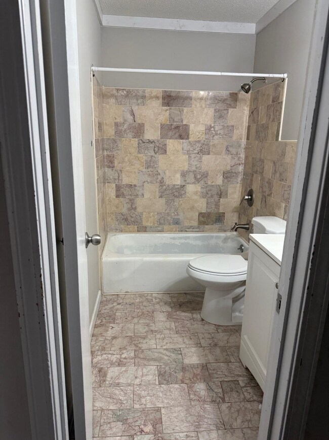 Bathroom featuring toilet, vanity, shower / tub co