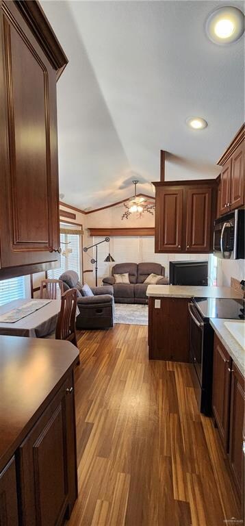 Kitchen featuring stove, lofted ceiling, dark wood-style flooring, open floor plan, and dark brown cabinetry