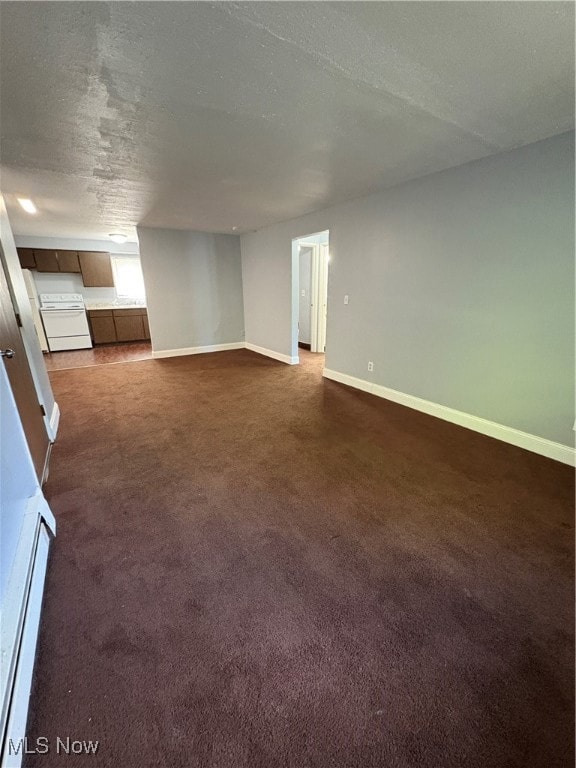 Unfurnished living room featuring a textured ceiling and dark colored carpet