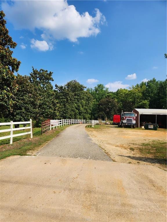 View of asphalt driveway featuring a forest view