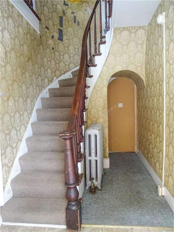 The foyer features this gorgeous winding staircase