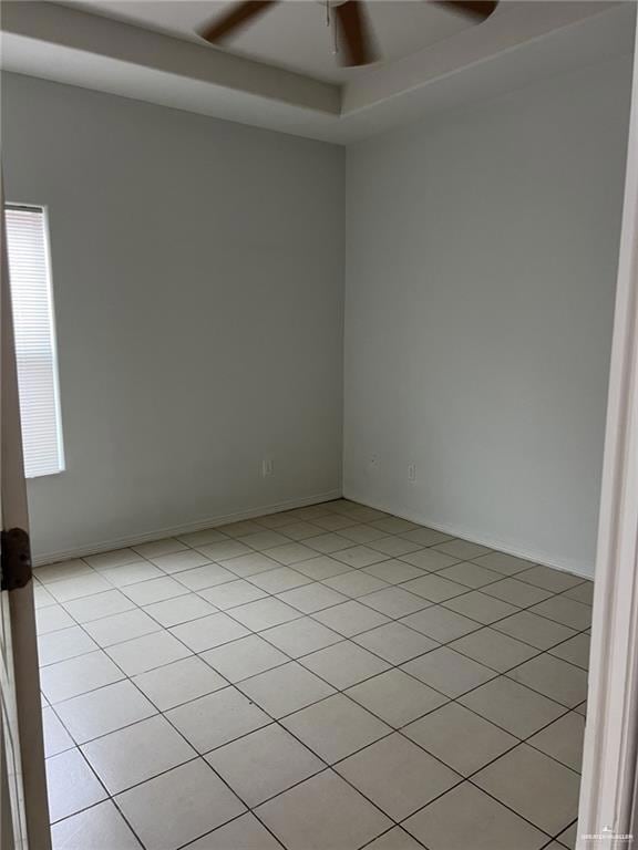 Spare room with ceiling fan and light tile patterned floors