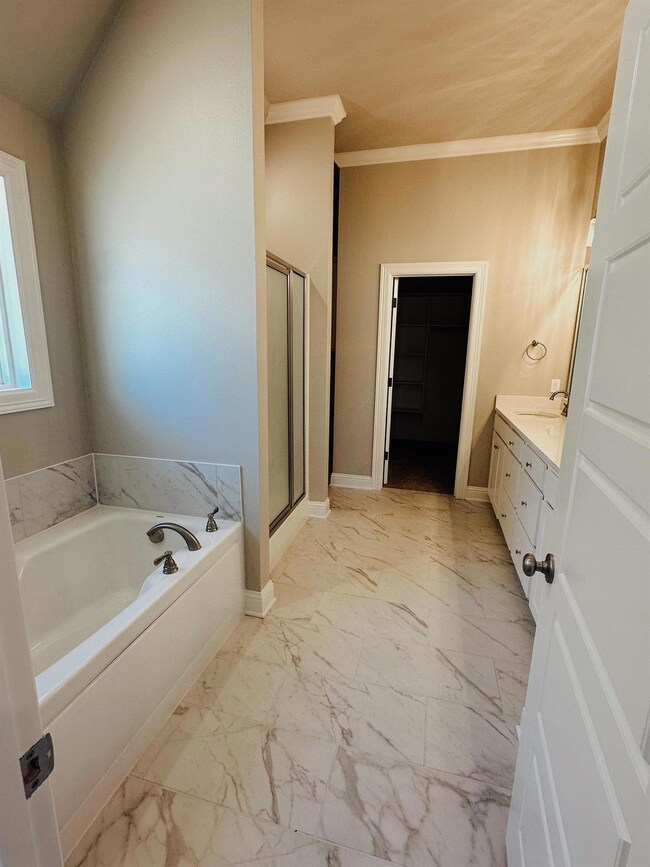 Bathroom featuring vanity, tile floors, shower wit