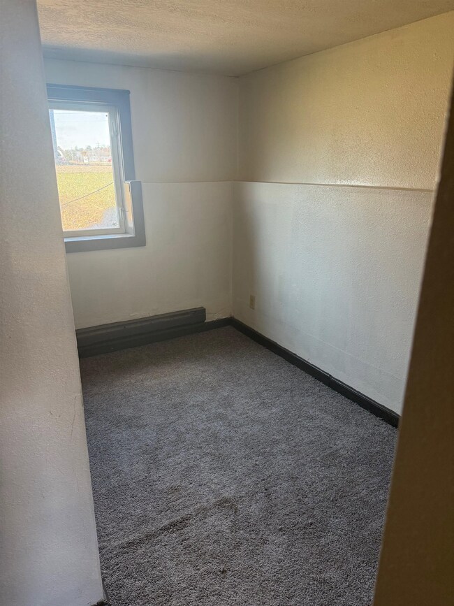Carpeted spare room with baseboards and a baseboar