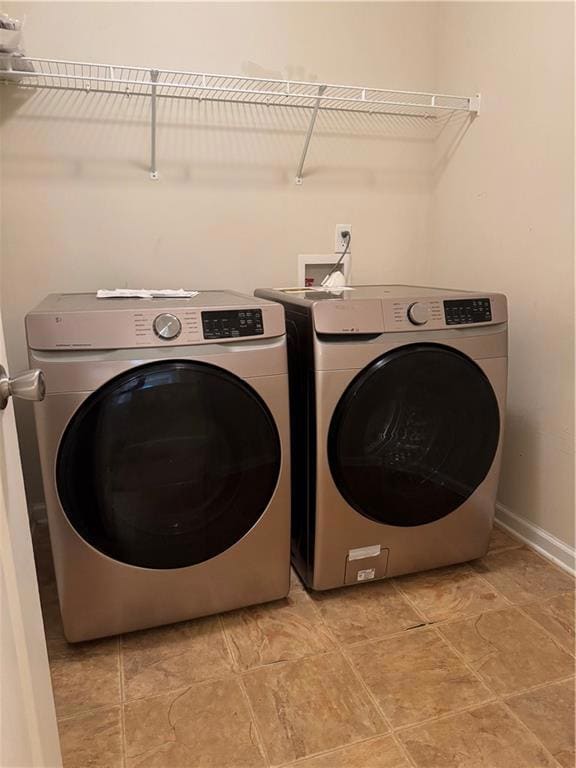 Laundry room featuring washing machine and clothes dryer and light tile patterned floors