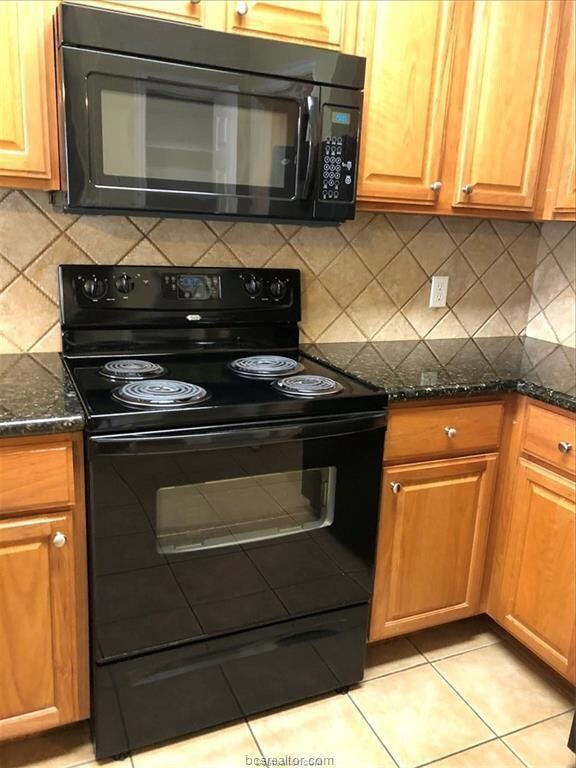 Kitchen with decorative backsplash, black applianc
