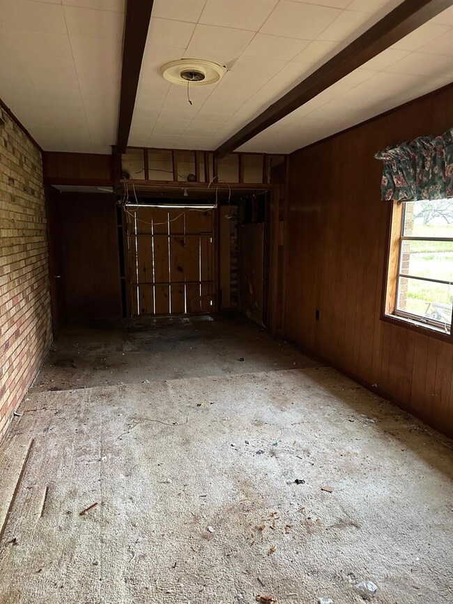 Spare room featuring wooden walls, brick wall, and