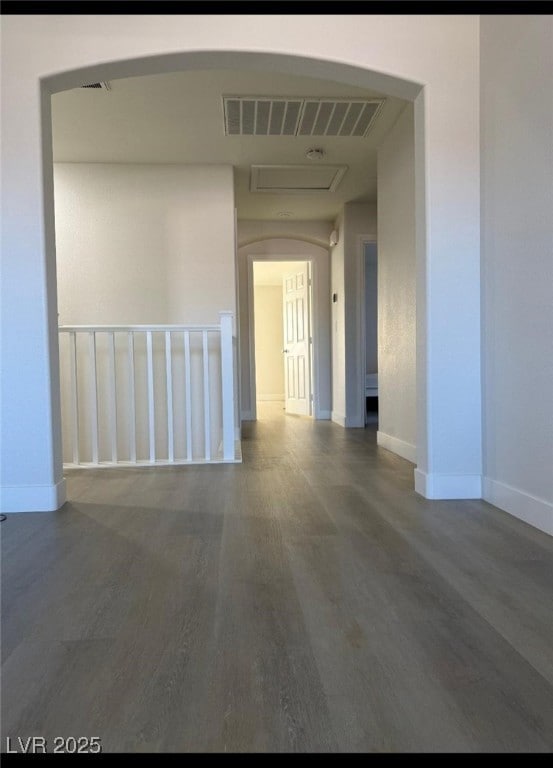 Empty room with wood finished floors, arched walkw