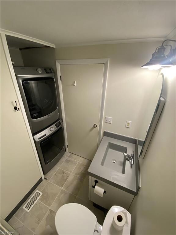 Bathroom with tile floors, toilet, sink, and stack