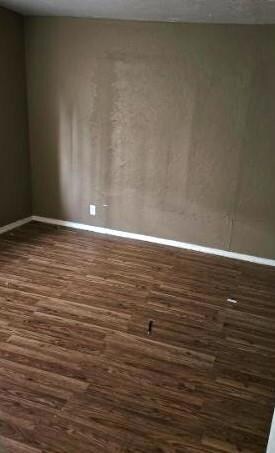 Empty room featuring dark hardwood / wood-style fl