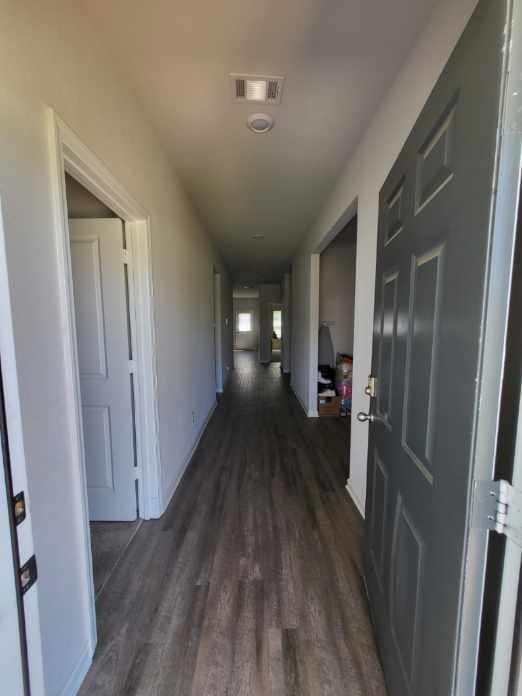 Hallway featuring dark wood-type flooring and baseboards