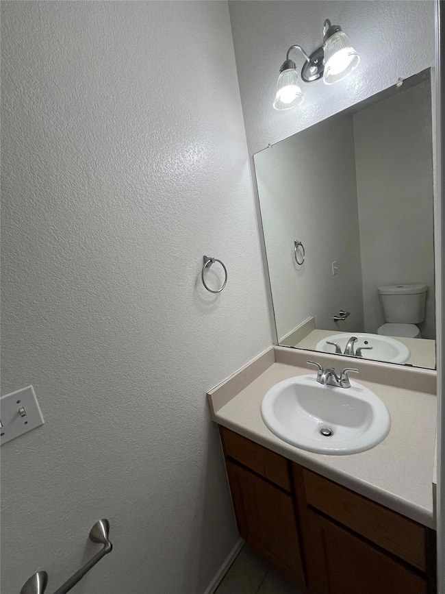 Bathroom with vanity, toilet, and tile patterned 