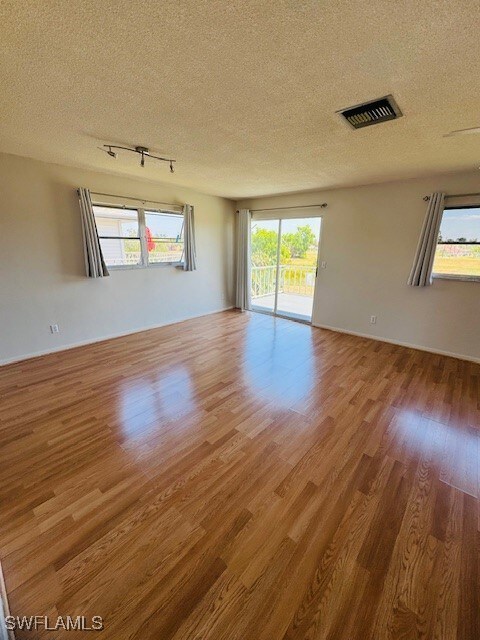Spare room featuring visible vents, wood finished