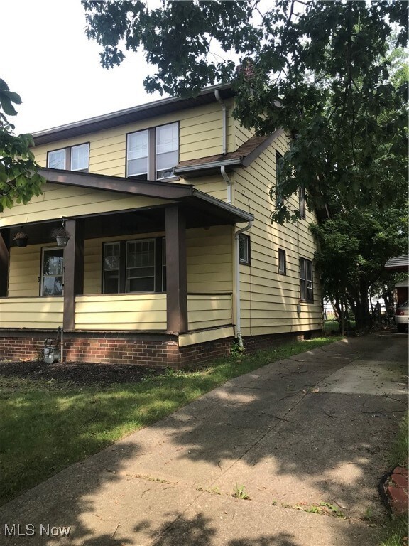 View of side of home featuring covered porch