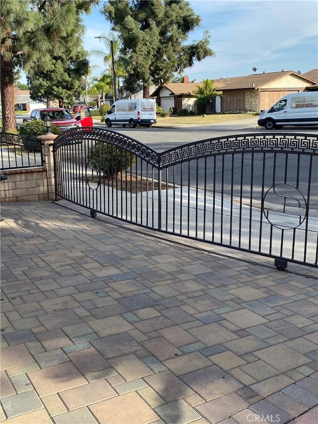 SLIDING DRIVEWAY FENCE FEAUTURING DECORATIVE CUSTOM DESIGN