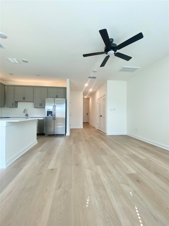 Unfurnished living room featuring a ceiling fan a