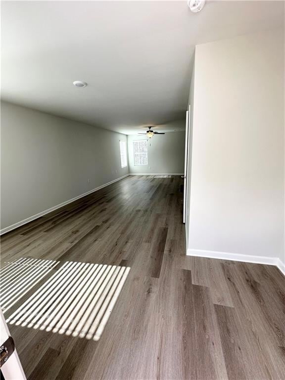 Spare room featuring wood finished floors, baseboards, and ceiling fan