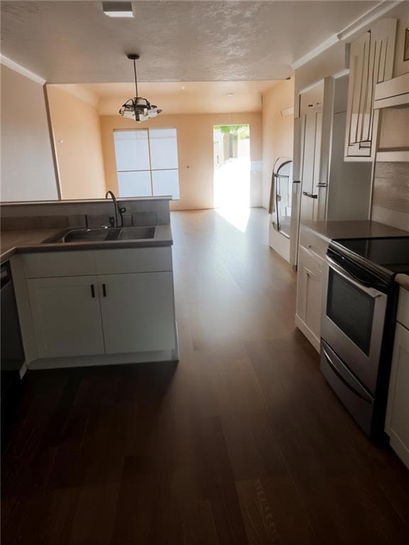 Kitchen with stainless steel range with electric cooktop, dark wood finished floors, pendant lighting, and white cabinetry