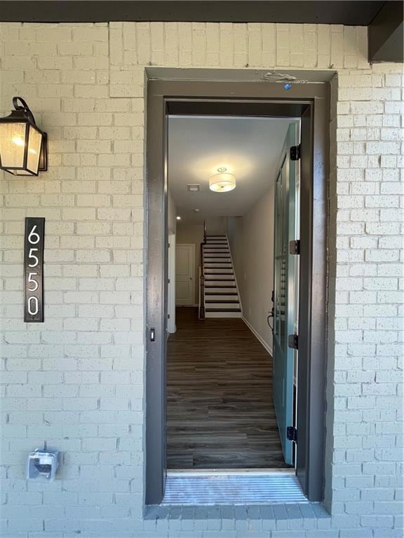 View of exterior entry featuring brick siding