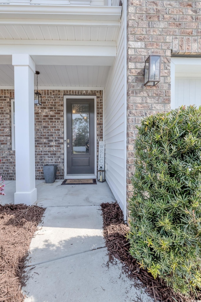 View of exterior entry featuring brick siding and 