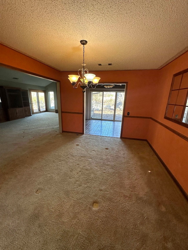 Unfurnished room with baseboards, visible vents, a