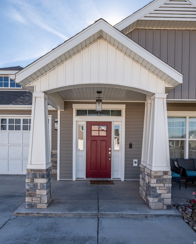 View of exterior entry with a porch, board and batten siding, and a garage