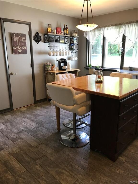 Kitchen window overlooks scenic backyard, door to 