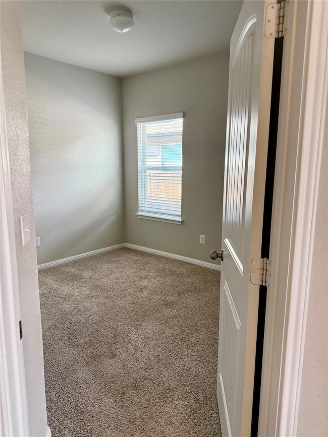 Unfurnished room featuring carpet flooring and ba