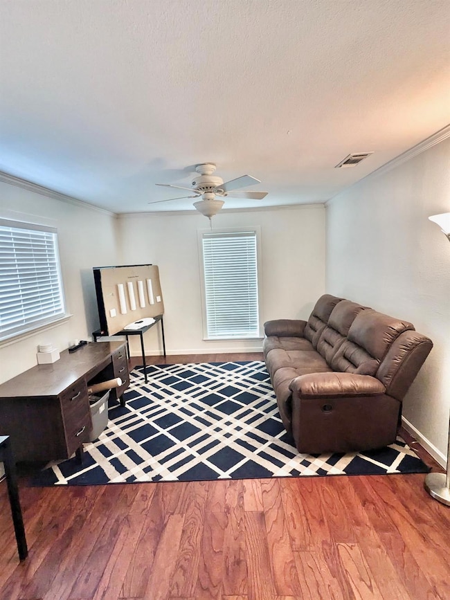 Living room with crown molding, visible vents, wo